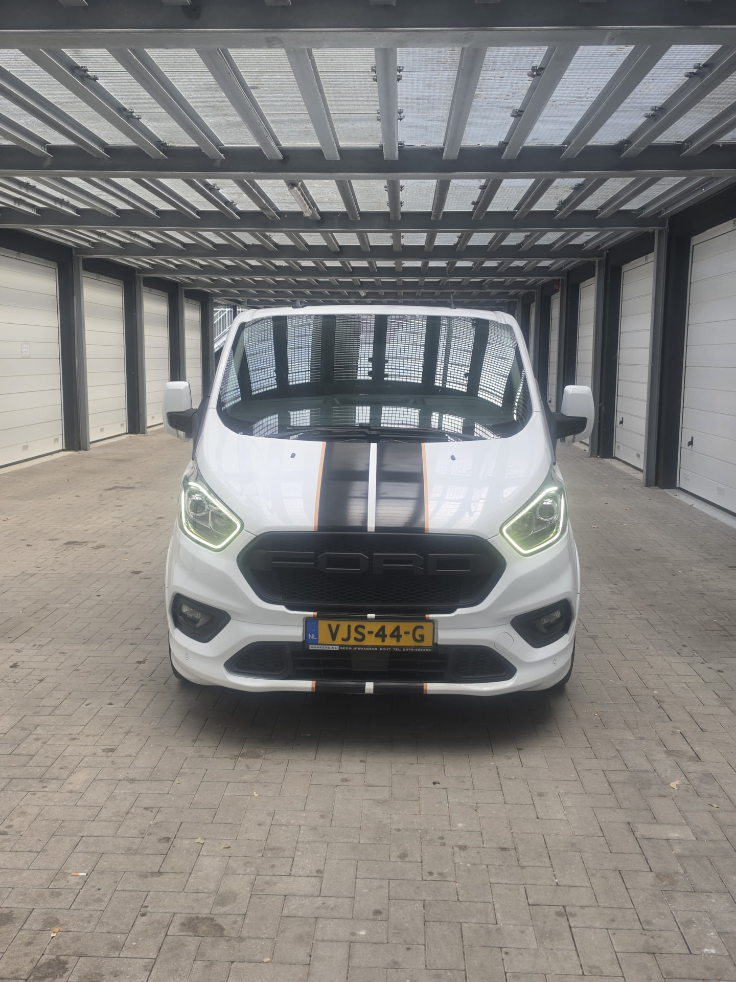 Furgoneta blanca de maniakauto con franjas negras, lista para salir a trabajar