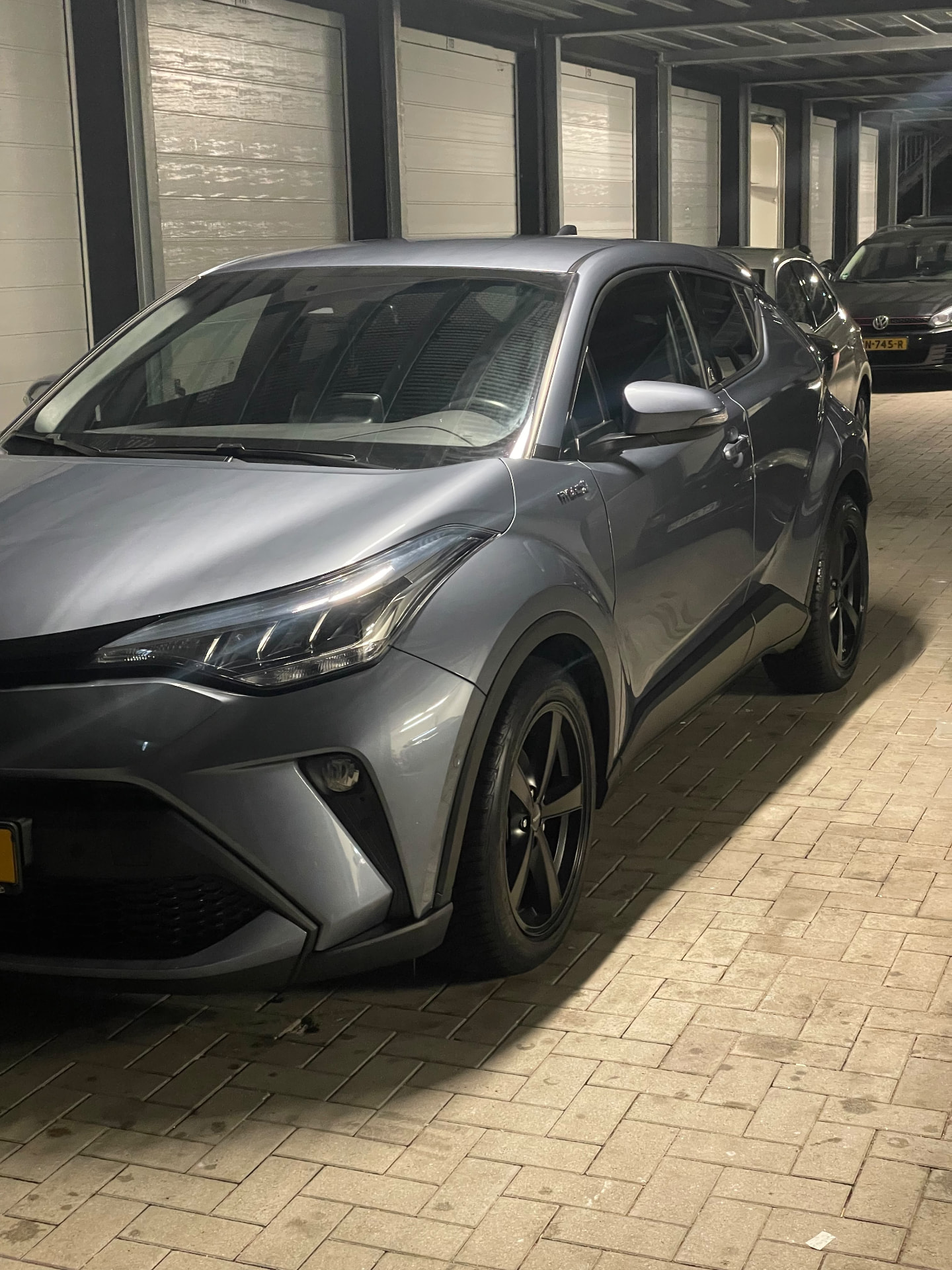 Toyota C-HR gris de tres cuartos con la pintura metalizada muy brillante