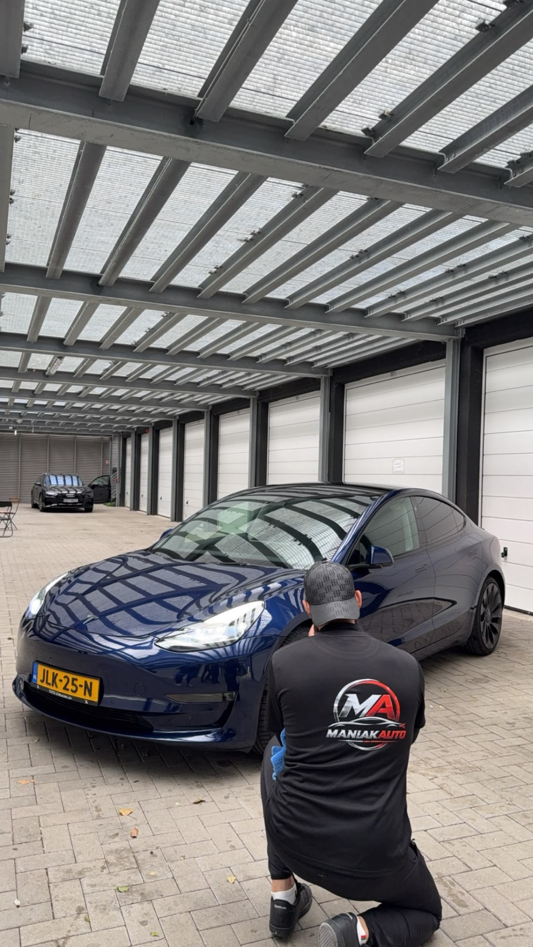 Tesla Model 3 azul oscuro de frente con la pintura recién pulida